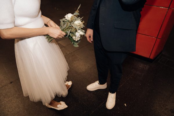Foto von Brautpaar dessen Schuhe und Hochzeitsstrauß man sieht